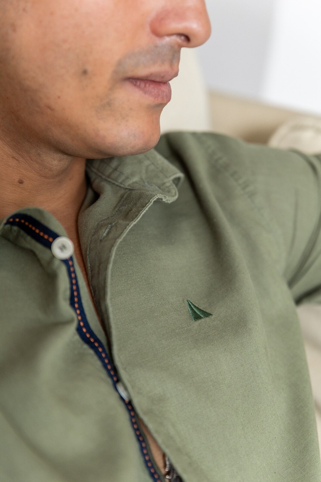 Close-up of an olive linen shirt collar with the AnationZ emblem
